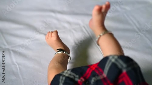 Small Legs of baby. Newborn Baby girl. Baby in skirt. Indian leg anklets. Moving