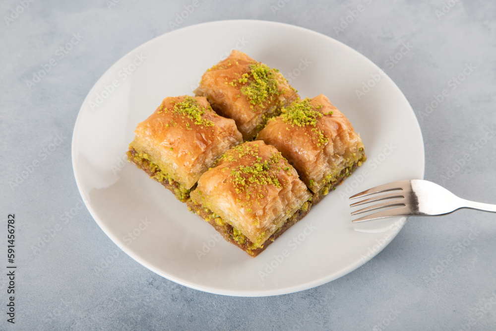 Pistachio baklava on a white plate with Turkish coffee,top view
Pistachio baklava on a white plate with Turkish coffee,top view