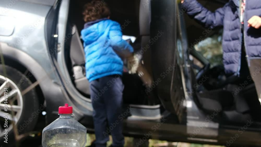 Kids helping their young adult parents to wash car outdoors in backyard on hot summer day Kids helping their young adult parents to wash car outdoors in backyard on hot summer day