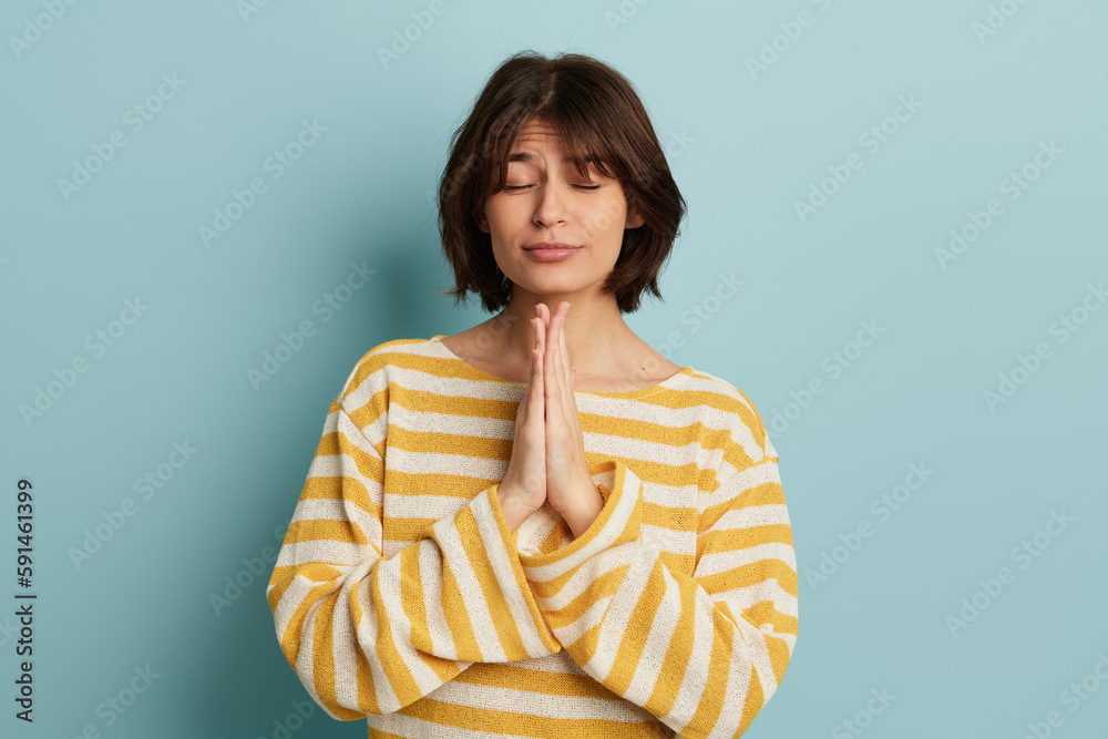 Woman with closed eyes and praying hands Woman with closed eyes and praying hands