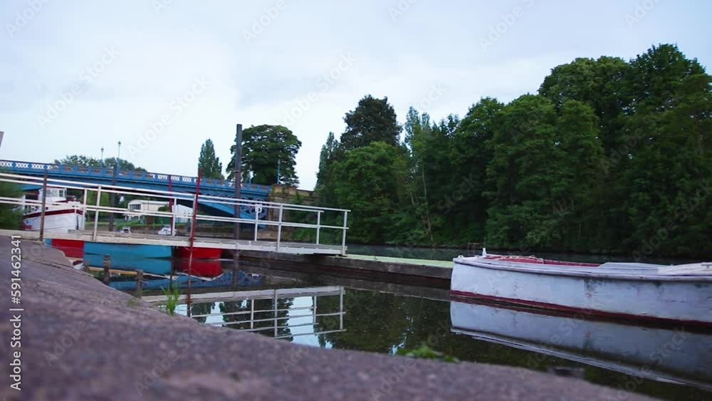 Pan across river bank and moored boats