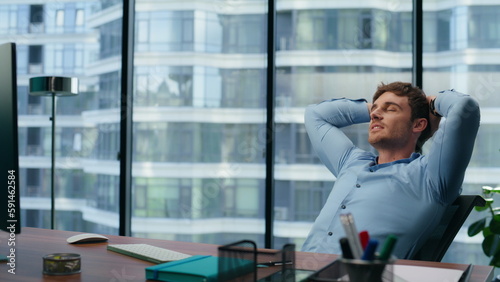 Confident director having break on office chair. Businessman relaxing enjoying