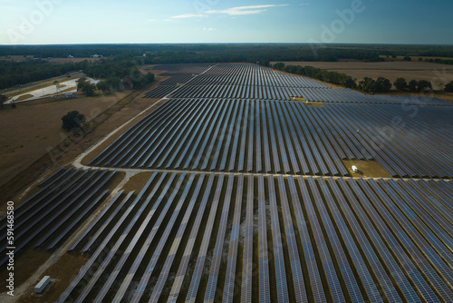 Aerial view of large sustainable electrical power plant with rows of solar photovoltaic panels for producing clean electric energy. Concept of renewable electricity with zero emission