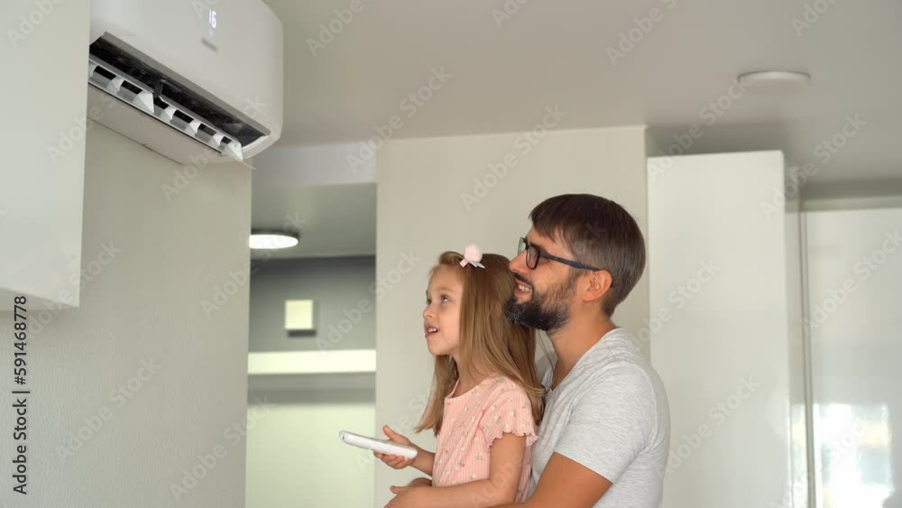 Father and little daughter turn on air conditioner using remote control. Cooler system. Summer heat Father and little daughter turn on air conditioner using remote control. Cooler system. Summer heat
