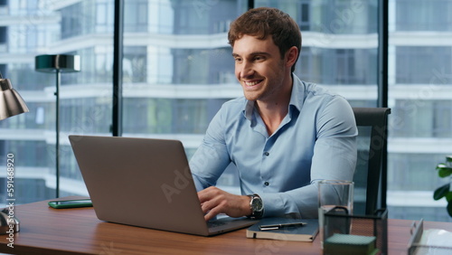 Happy boss working laptop in city view office. Manager chatting social media