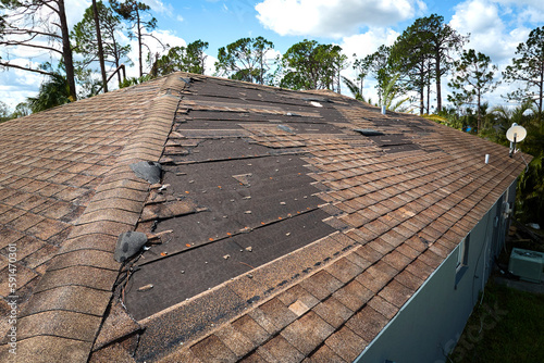 Canvas Print Damaged house roof with missing shingles after hurricane Ian in Florida