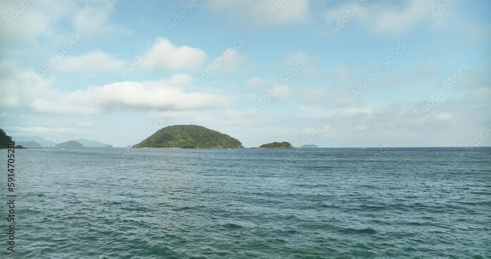 Seascape at sunny day, low aerial flying over sea waters towards islands Seascape at sunny day, low aerial flying over sea waters towards islands
