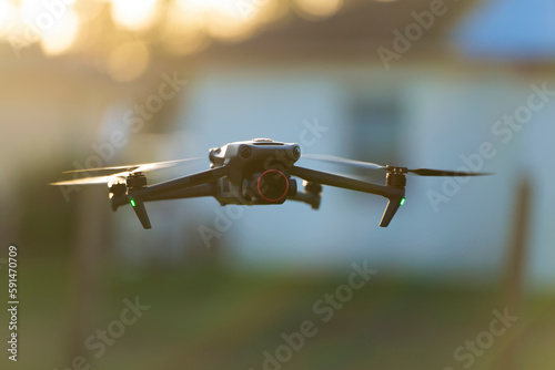 Drone aircraft with blurred fast rotating propellers and video camera flying in air