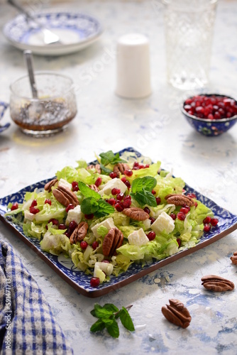 Salad of feta cheese and pecans, garnished with pomegranate seeds and dressing