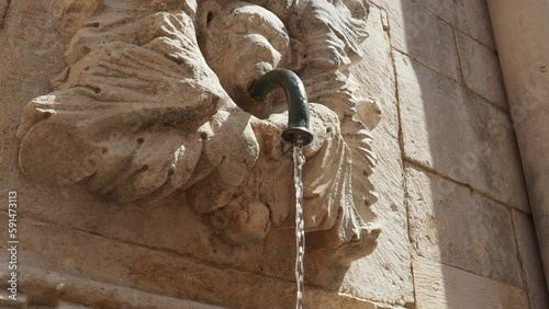 Dubrovnik, Croatia 08.14.2022 Onofrio's Big Fountain by Onofrio della Cava. Water flows from a tube sticking out of the mascaron's mouth. Ancient plumbing. Fountain, high relief with decorations. photo