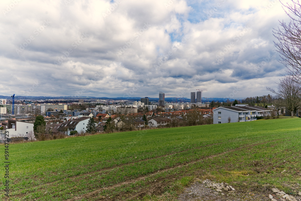 Scenic view over rural landscape and agriculture fields with skyline of Stettbach in the background on a cloudy winter day. Photo taken February 26th, 2023, Zurich, Switzerland.