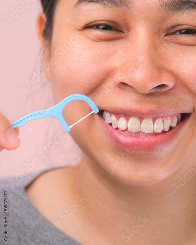 Close-up of smiling asian woman and cleaning for perfect smile. Healthy white teeth by flossing, oral health and dental care.