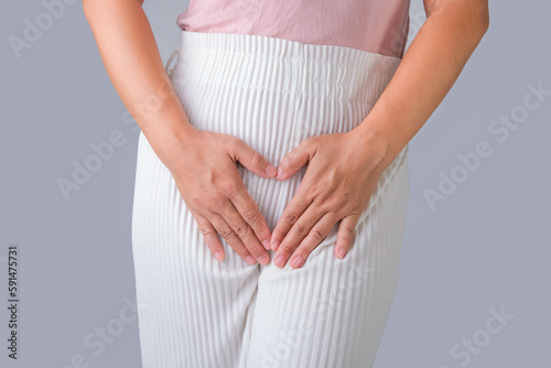 Woman with hands on her crotch isolated on white background. Female hand holding her crotch with pelvic pain or vaginal itching. gynecological problems. Health hygiene concept