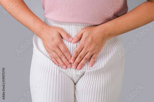 Woman with hands on her crotch isolated on white background. Female hand holding her crotch with pelvic pain or vaginal itching. gynecological problems. Health hygiene concept