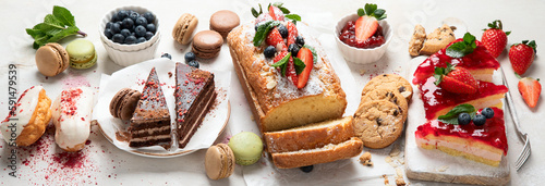 Table with various cookies, cakes and fruits. Delicious dessert table.