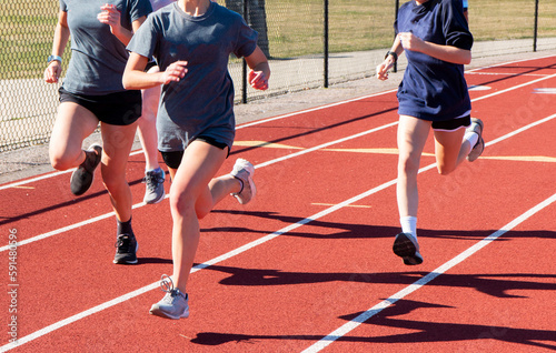 Three runners running fast in lanes on a track