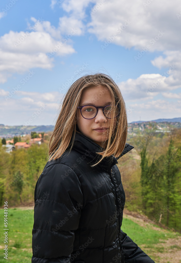 The girl walking outside in nature with sky and hills in the background The girl walking outside in nature with sky and hills in the background