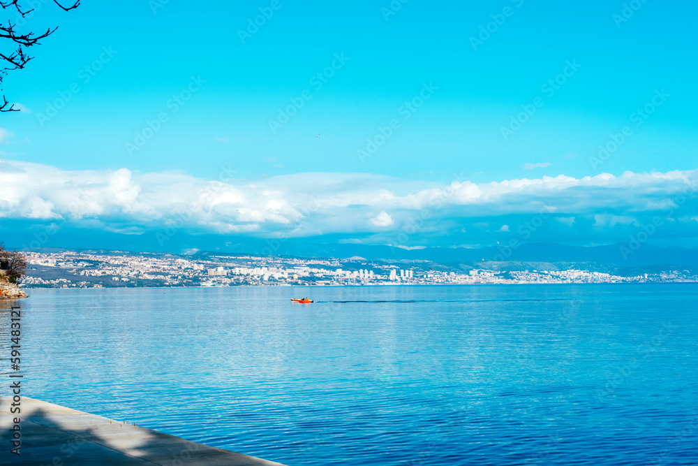 Beautiful blue sea with fishing boat. View of Rijeka city, Croatia