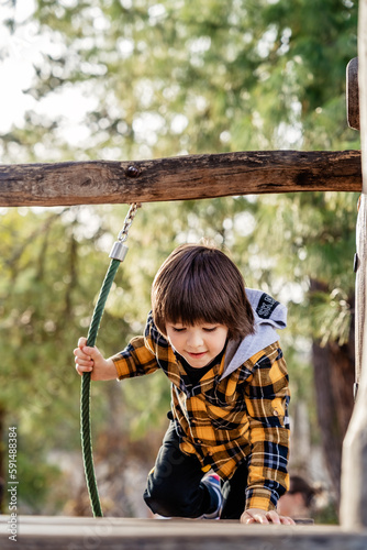 Child climbing up in rope park