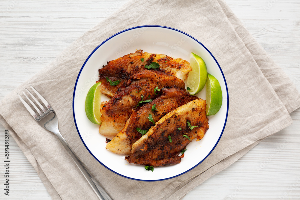 Homemade Pan Seared Tilapia on a Plate, top view. Flat lay, overhead, from above.