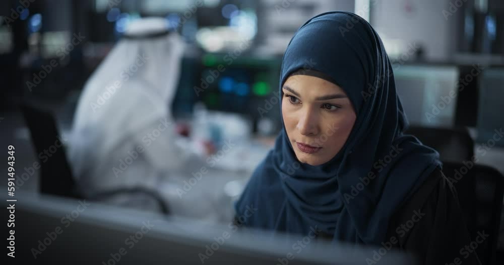 Portrait of a Thoughtful Middle Eastern Engineer Working on Computer in a Technological Corporate Office. Young Woman Writing Software Code for an Innovative Internet and Software as a Service Project Portrait of a Thoughtful Middle Eastern Engineer Working on Computer in a Technological Corporate Office. Young Woman Writing Software Code for an Innovative Internet and Software as a Service Project