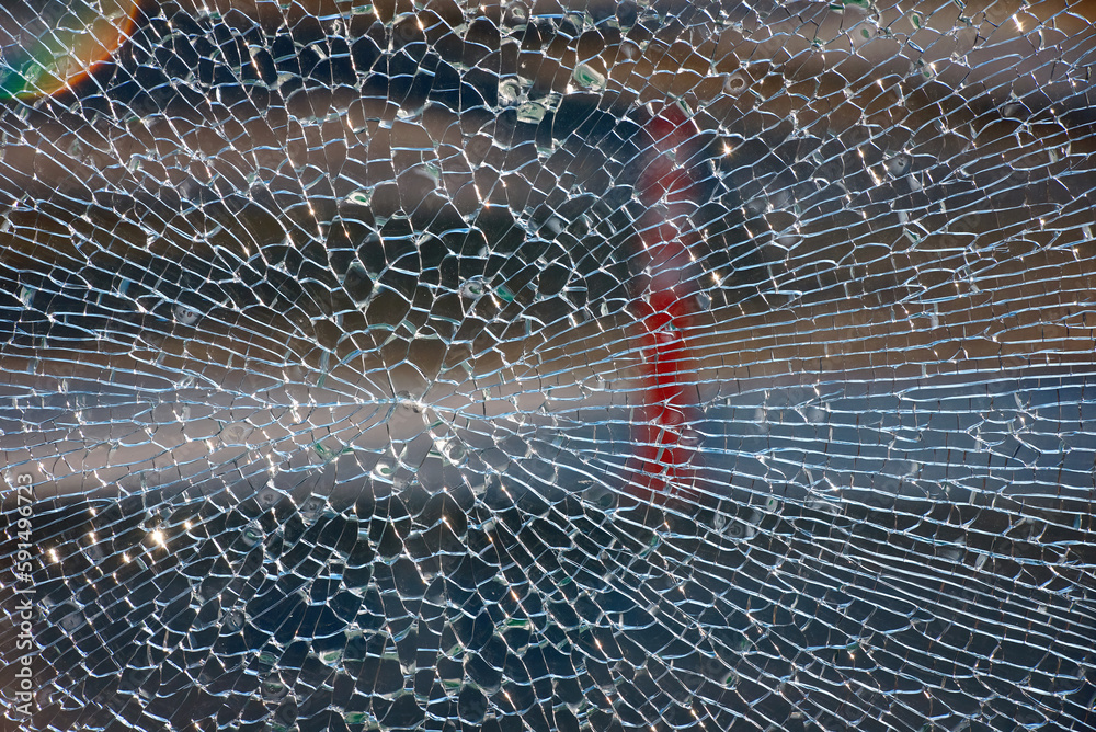 Broken tempered glass exterior, outdoor background. Cracks on broken