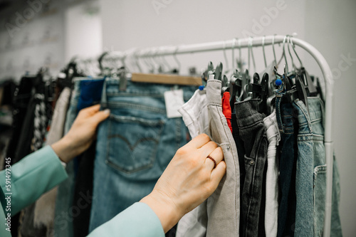 Customer choosing jeans from rack in store photo