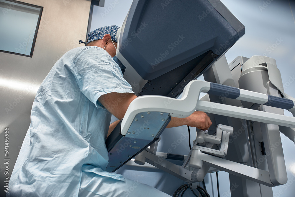 The surgeon is at the computer robot in a special control module, the ...