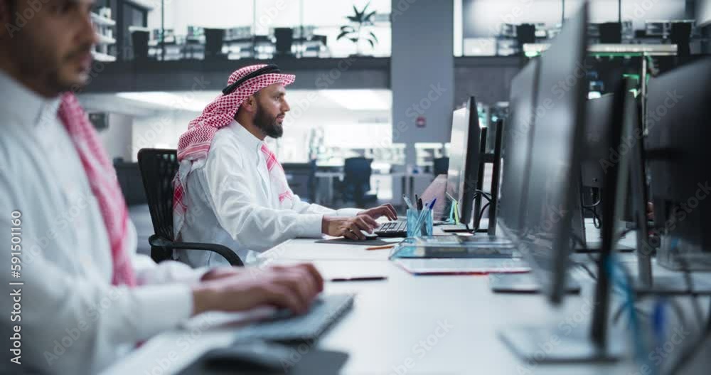 Portrait of a Middle Eastern Engineer Working on Desktop Computer in a Technological Office Environment. Arab Software Developer Researching New Ideas to Problem Solve a Technical Assignment Portrait of a Middle Eastern Engineer Working on Desktop Computer in a Technological Office Environment. Arab Software Developer Researching New Ideas to Problem Solve a Technical Assignment