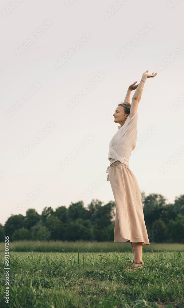 Woman with arms raised stretching in nature Woman with arms raised stretching in nature