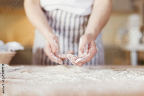 Hands of young woman covered in flour photo