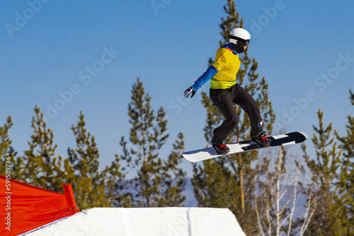 woman athlete snowboarders in team France jumping drops in snowboarding competition, winter sports photo