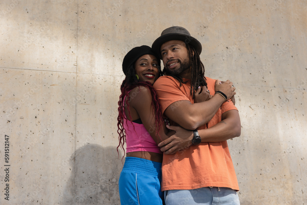 Portrait of African-American couple embracing each other. Smiling happy girlfriend and boyfriend enjoy outside.
