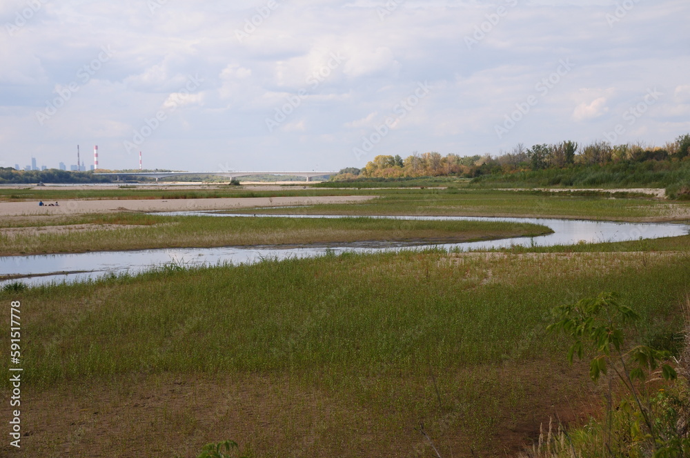 Meandrująca rzeka z mostem i miastem w tle Meandrująca rzeka z mostem i miastem w tle