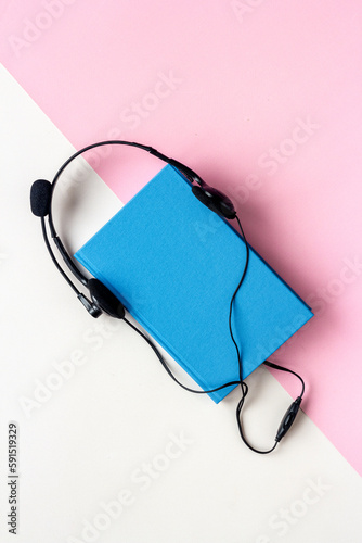 Audiobook or podcast concept with book and headphones nearby
