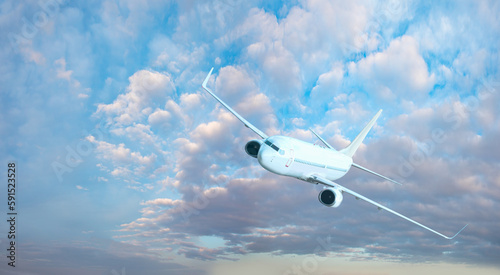 White passenger airplane flying in the sky amazing clouds in the background - Travel by air transport