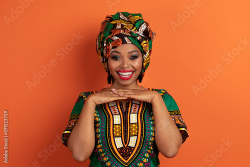 Cute beautiful young black woman posing on orange background