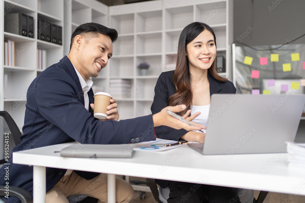 The couple of business employee working in the office with laptop and holding the coffee cup, happy, The couple of business employee working in the office with laptop and holding the coffee cup, happy,
