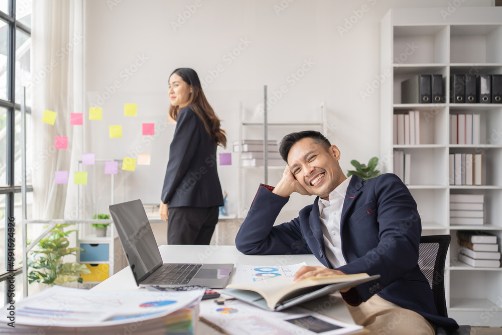 The couple of business employee working in the office with laptop and holding the coffee cup, happy, The couple of business employee working in the office with laptop and holding the coffee cup, happy,