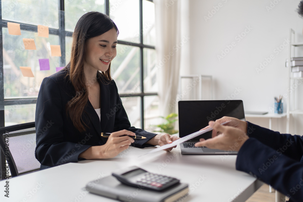 Close-up of a businessman shaking hands with a young Asian female, Work with document in the office. Close-up of a businessman shaking hands with a young Asian female, Work with document in the office.
