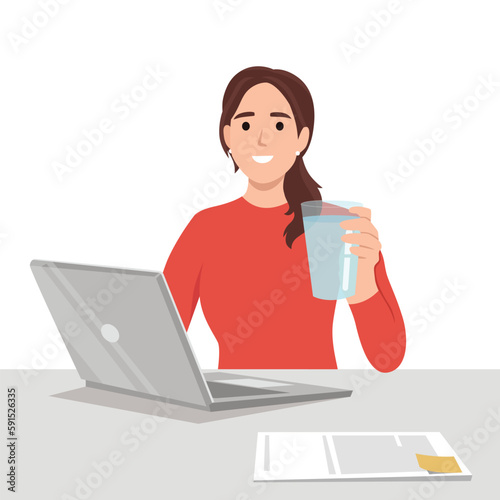 Young business woman holding glass of water in front of desk with laptop. Reminding people to stay hydrated and dont forget to drink water