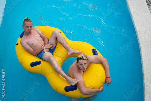 Young attractive couple have a rest in the summer in the water park.	