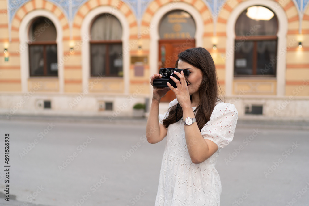 The young woman takes photos in the city