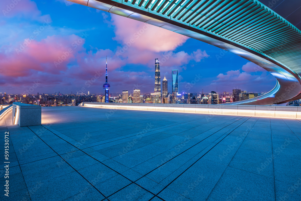 Empty square floor and bridge with city skyline at night in Shanghai, China.