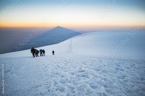 Climbers climbing Mount Ararat along the steep slope of the glacier in front of the summit, minimalist ascent of climbers © Denis