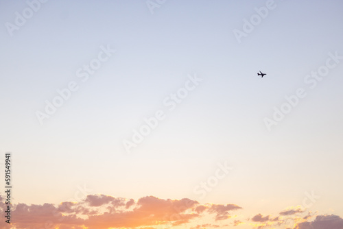 Schöner Sonnenuntergang im Sommer und Flugzeug am Himmel, Symbol für Urlaub und Tourismus