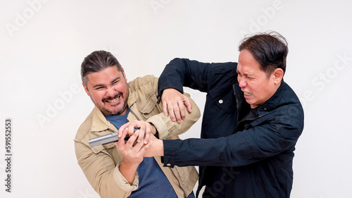 Two men fight over control a handgun. An undercover cop battling a criminal. Action scene isolated on a white backdrop. photo