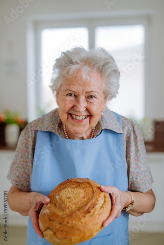 Portrait of senior woman with fresh baked bread.