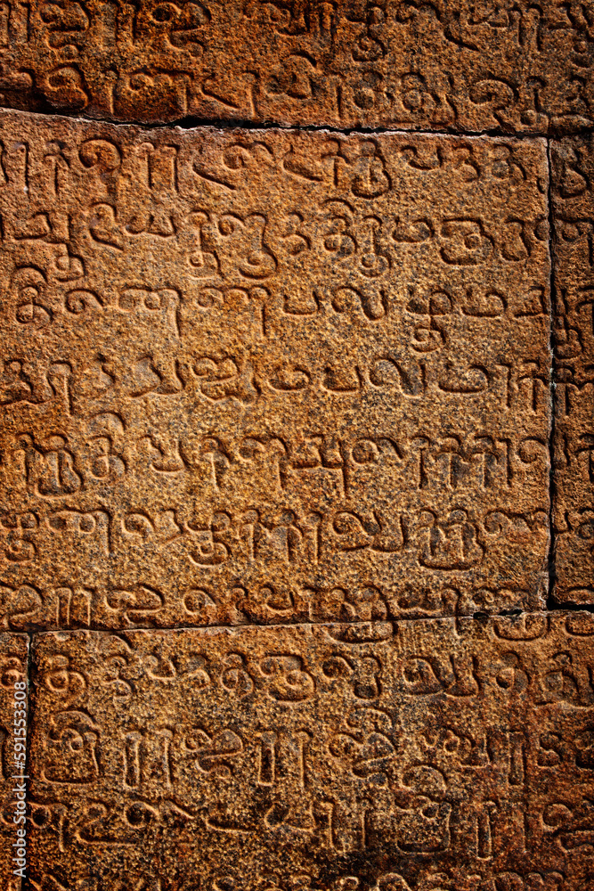 Ancient inscriptions on stone wall in Tamil language. India