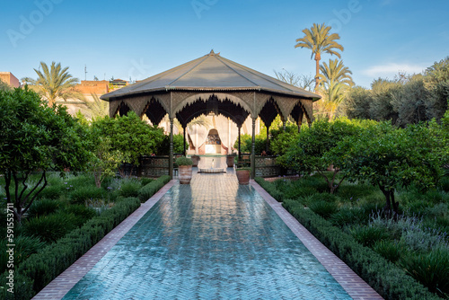 Gartenpavillon mit Palmen und blauem Weg photo